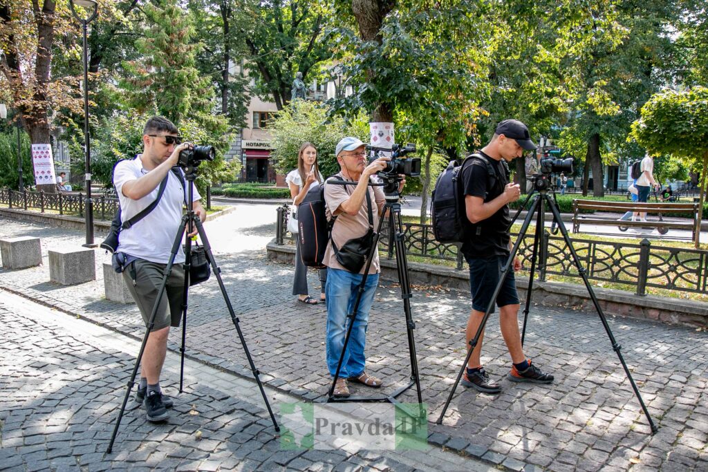 Фотографи працюють у парку з камерами на штативах.