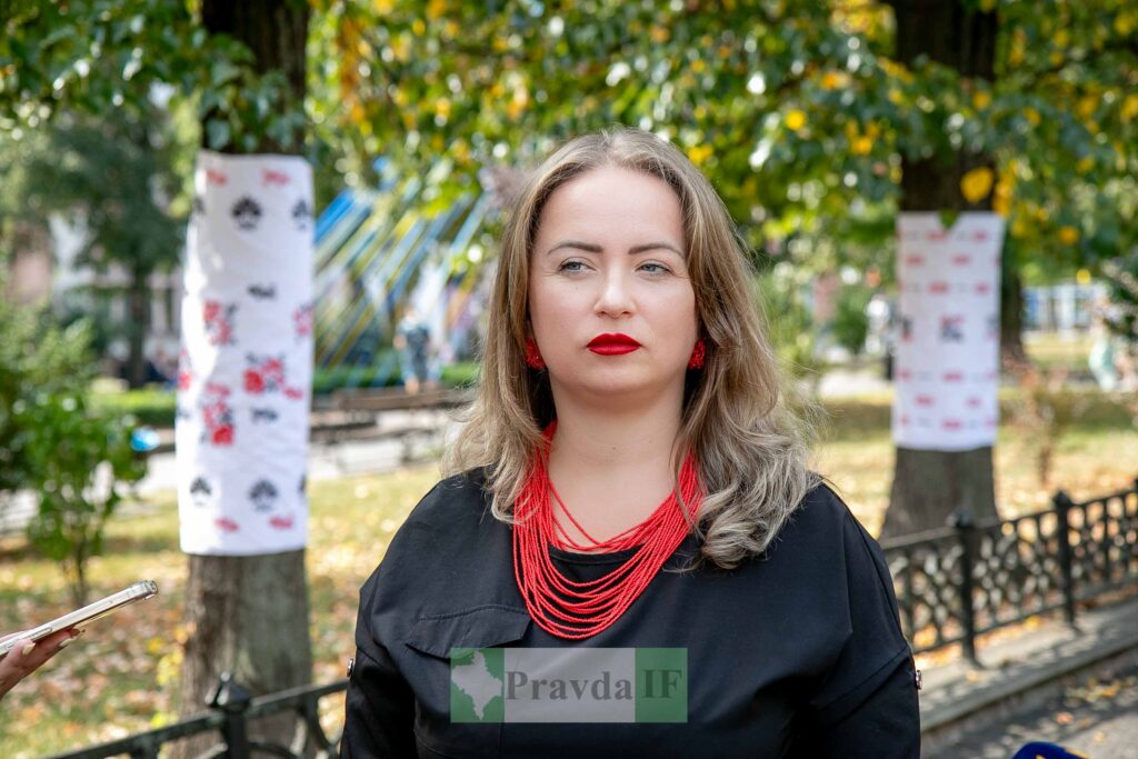 Жінка у парку з червоною прикрасою