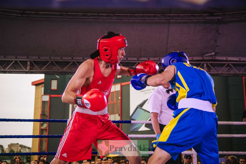 Боксери в червоній та синій формі на ринзі.
