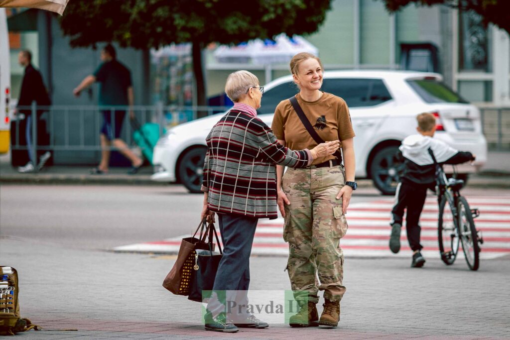 Дві жінки розмовляють на вулиці біля дороги.