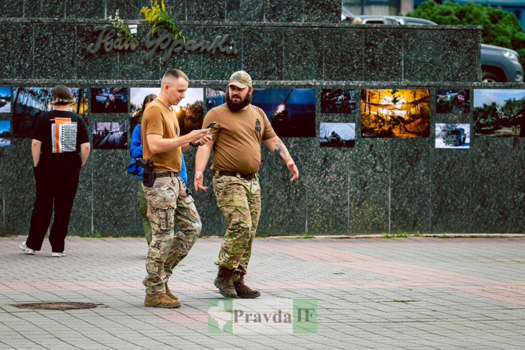 Військові оглядають світлини на вулиці Івано-Франківська.