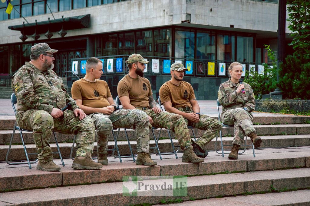 Військові сидять на сходах, вулична дискусія