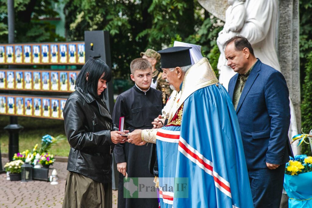 Церемонія нагородження медаллю жінки чоловіком у мантії.