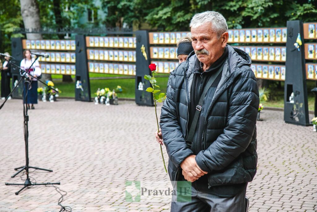 Чоловік з квіткою на меморіальному заході