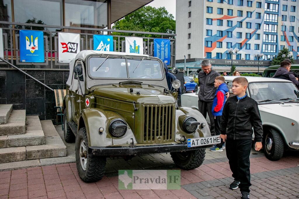 Військовий джип, люди поруч у місті.