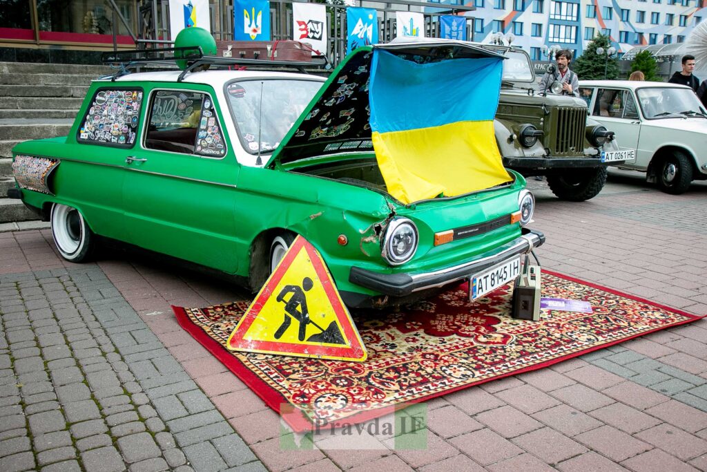 Зелений автомобіль ЗАЗ з українським прапором і знаками.