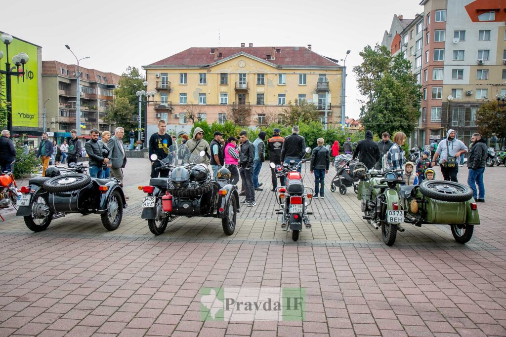 Люди на площі біля мотоциклів із колясками.