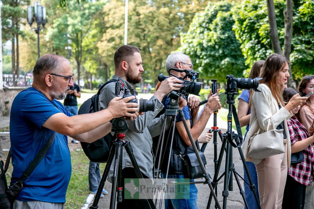 Журналісти з фотоапаратами в парку під час події.