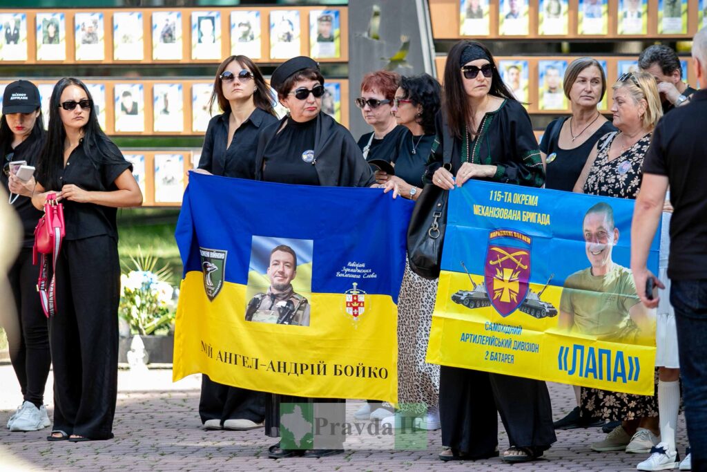 Люди з прапорами на меморіальному заході, Україна