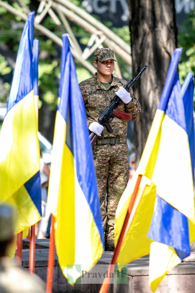 Солдат біля українських прапорів на вулиці