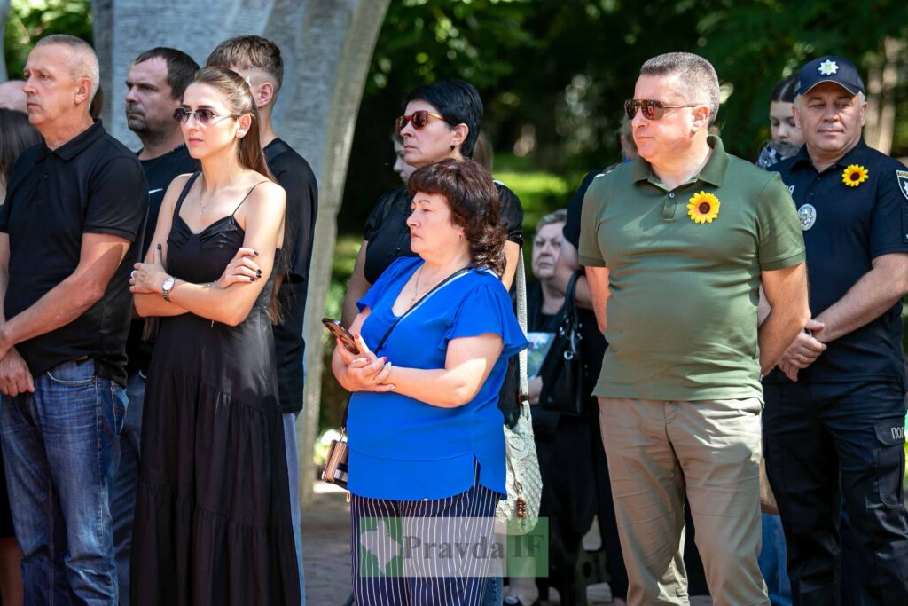 Люди на зібранні в парку з соняшниками.