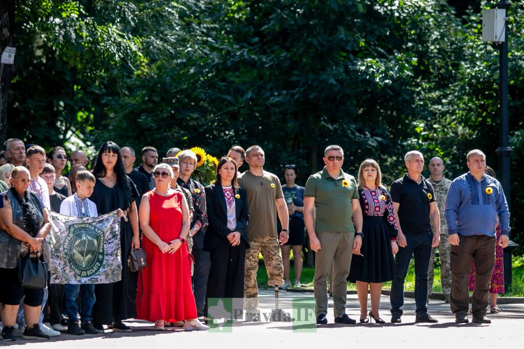 Група людей на вуличній події з символікою.