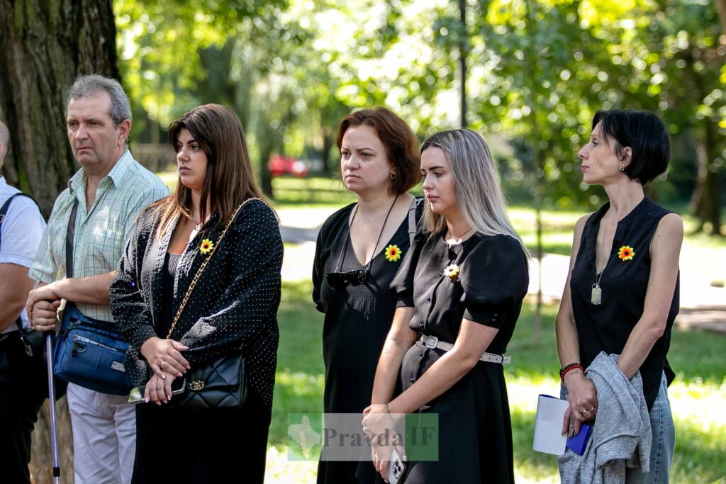 Люди на заході з жовтими квітами на одязі.