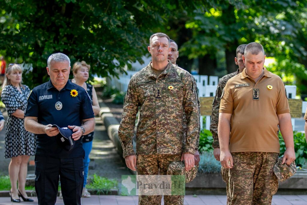 Люди у формі на вулиці, зелений фон.