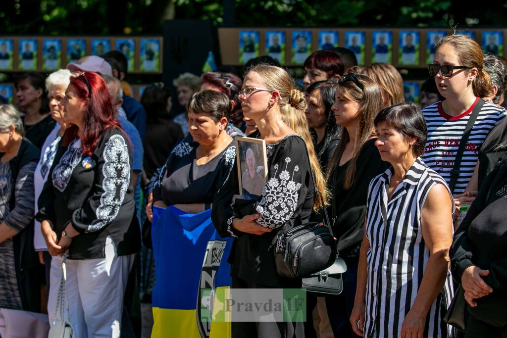 Люди на мітингу з українським прапором