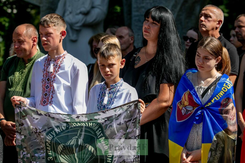 Люди з прапорами на церемонії вшанування