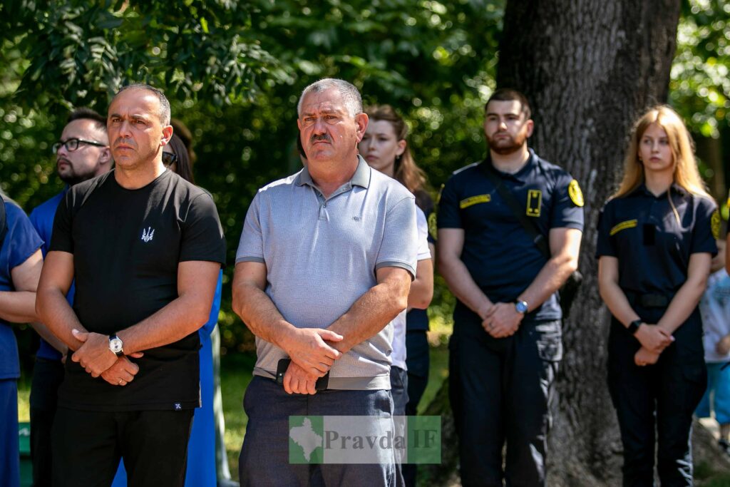 Група людей стоїть на вулиці в сонячний день.