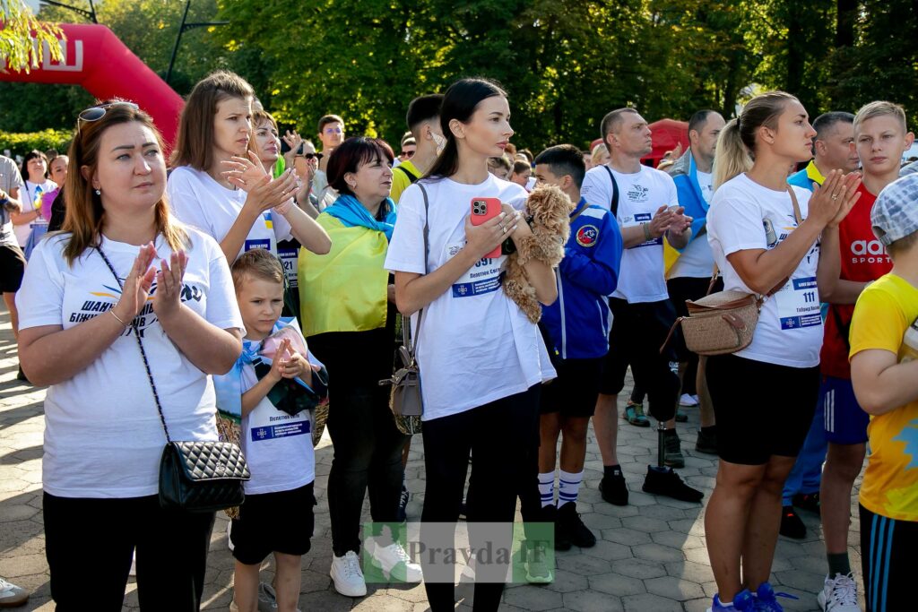 Люди аплодують на вуличному заході.