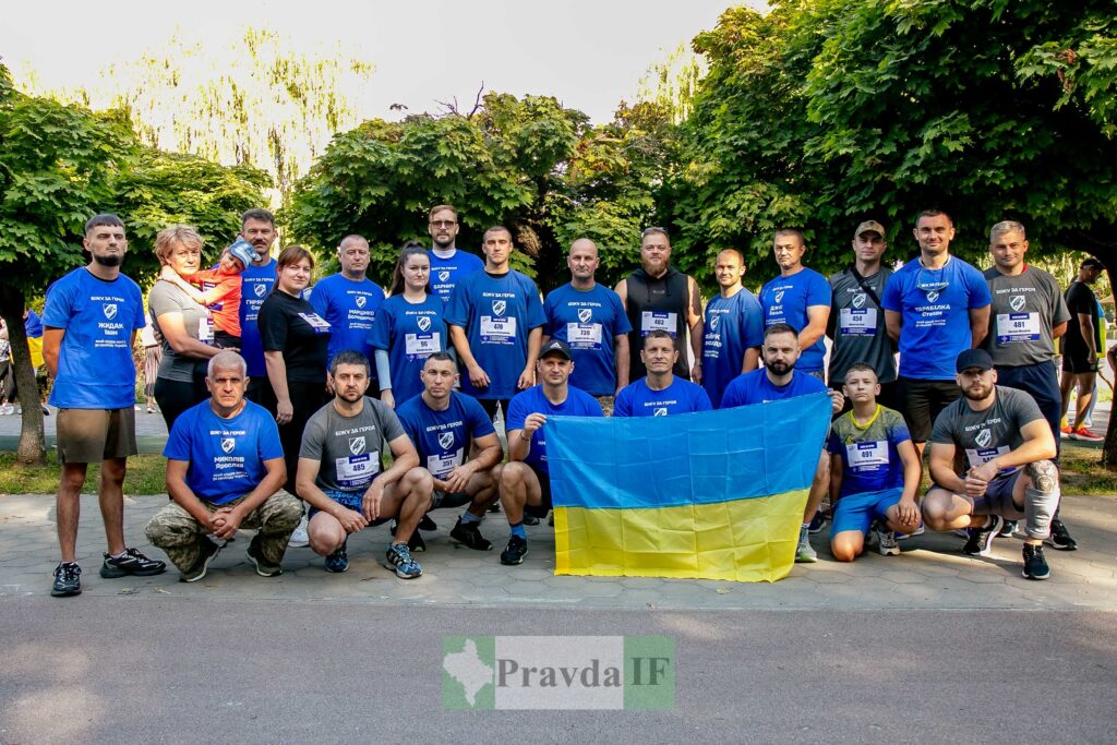 Група людей з українським прапором на природі.