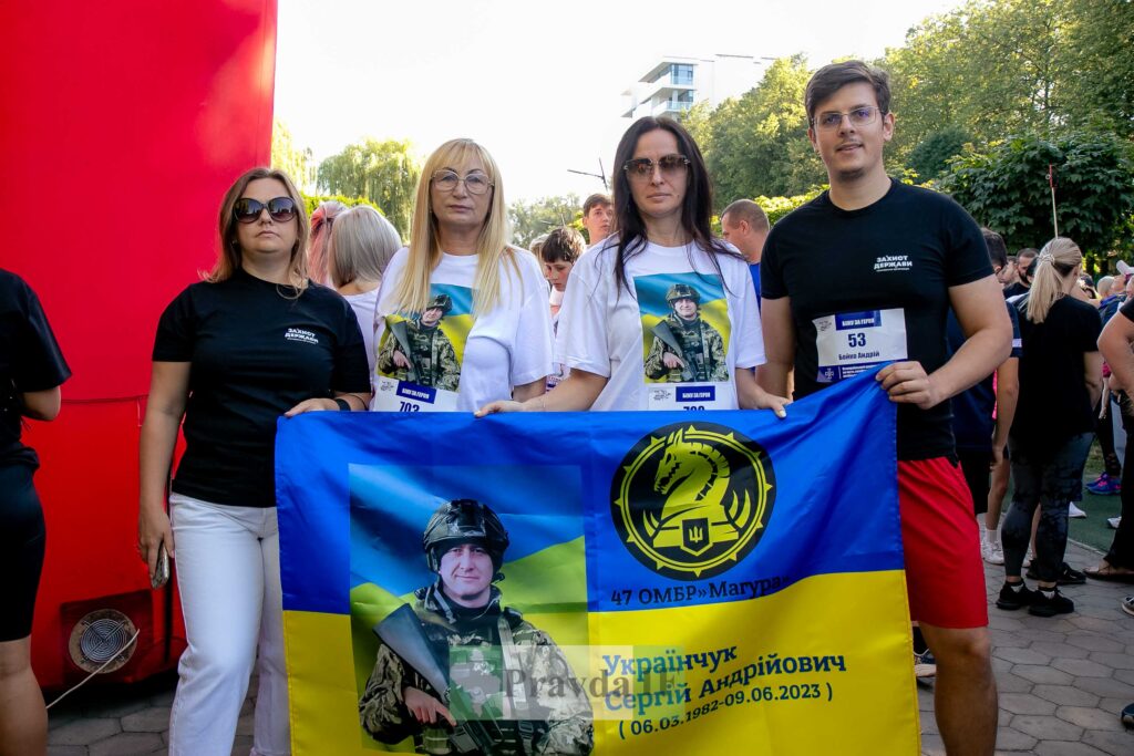 Люди тримають банер на вулиці під час заходу.