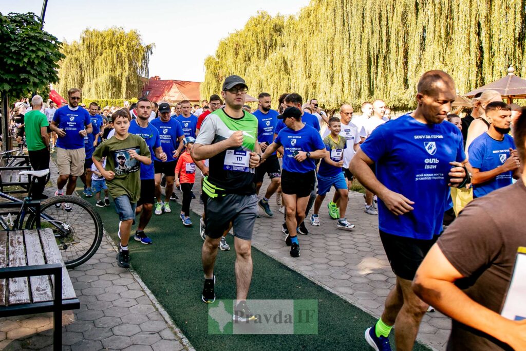 Забіг у парку з учасниками в синіх футболках.
