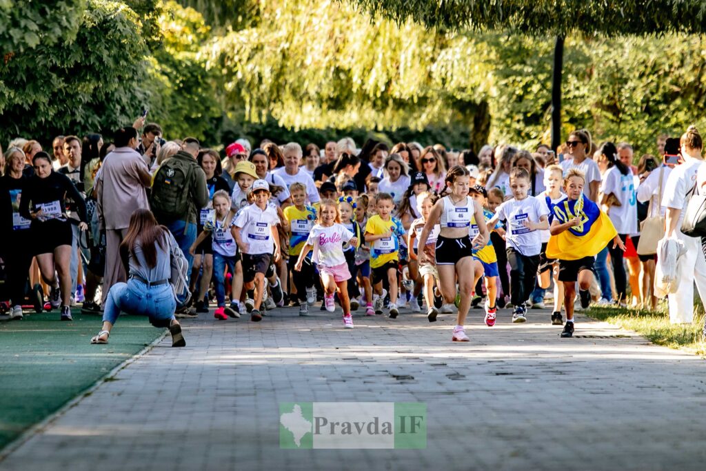Діти біжать на вуличному забігу з натовпом.