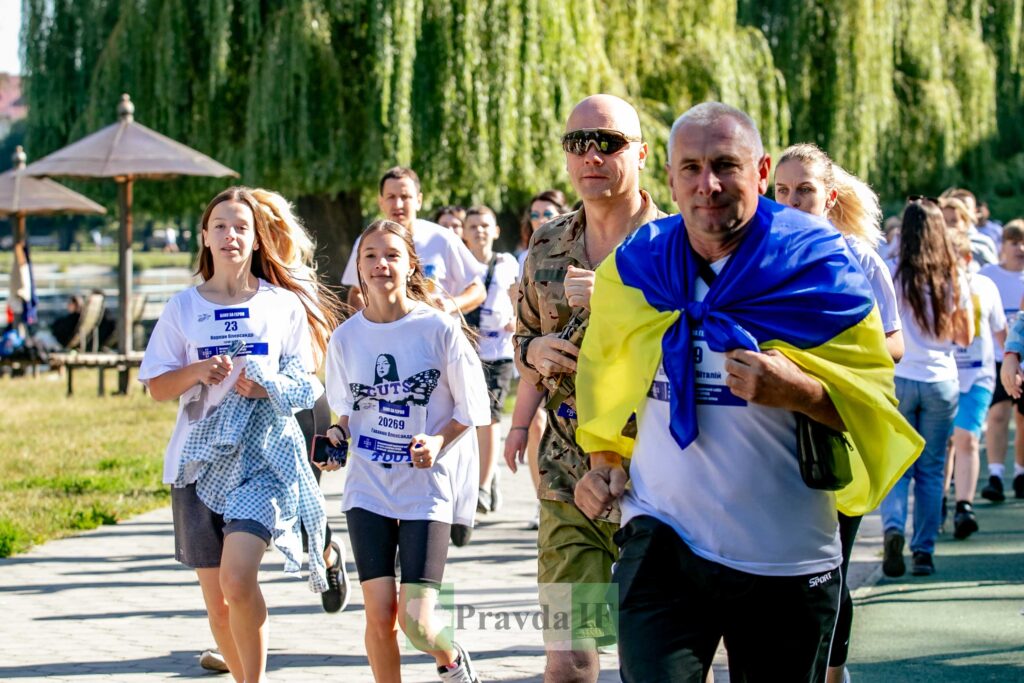 Група людей біжить у парку, спортивний захід.