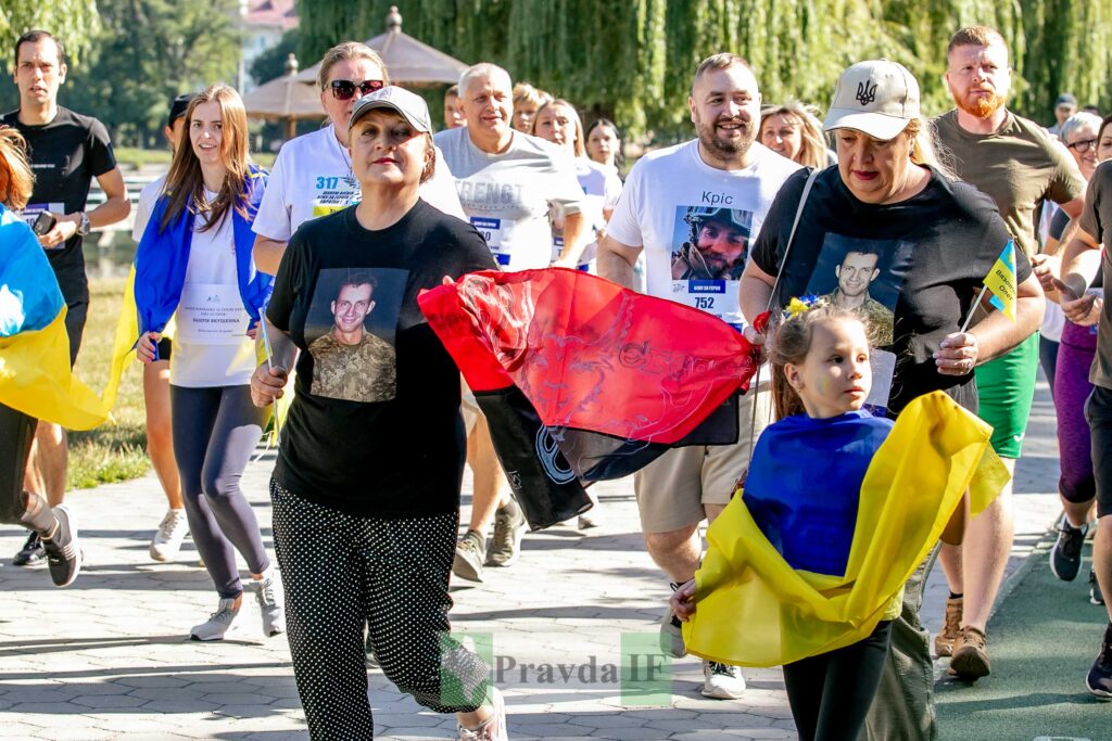 Люди біжать з українськими прапорами на забігу
