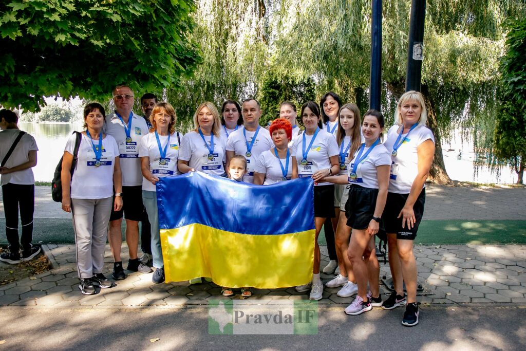 Група людей тримає прапор України на вулиці.