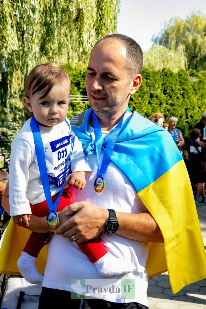 Тато з дитиною на заході з медалями.