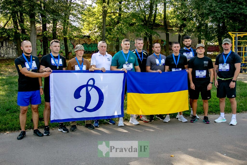 Спортсмени тримають прапори "Динамо" і України.