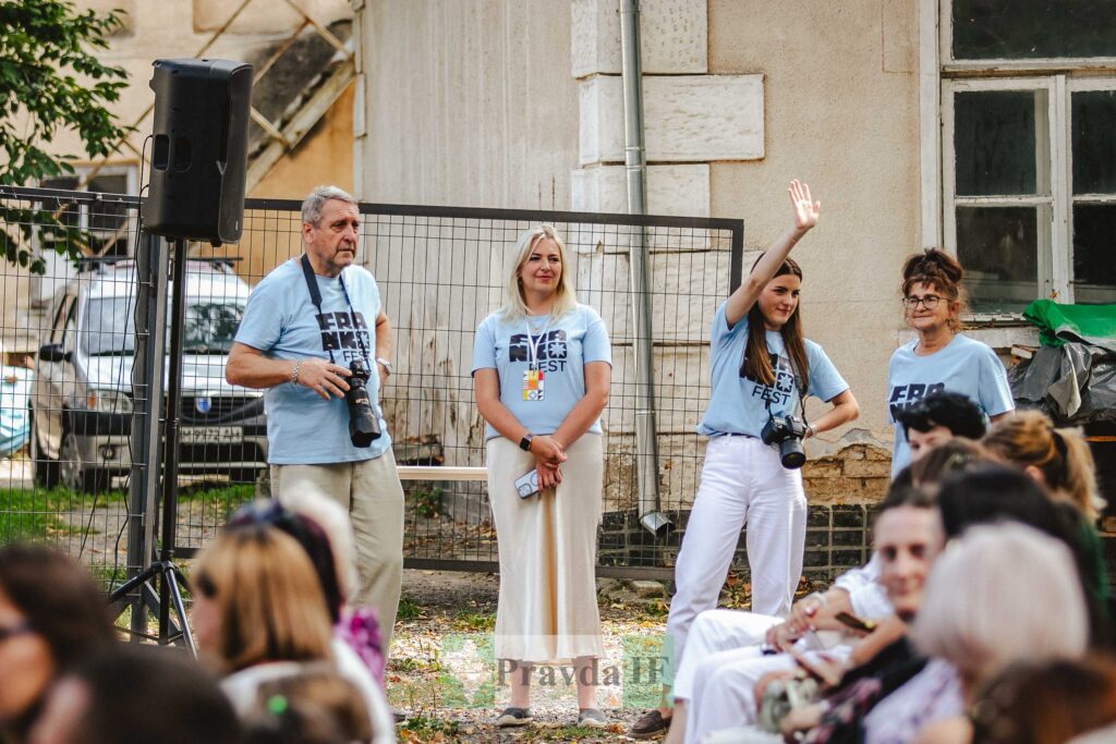 Група людей на вуличному фестивалі з фотоапаратами.