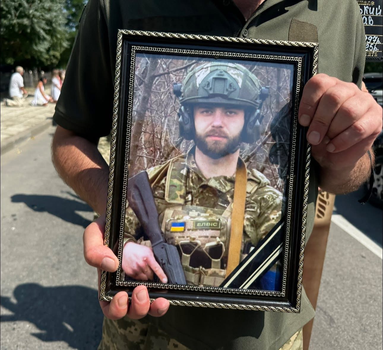 Фото військового в рамці на вулиці.