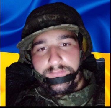 Військовий на фоні прапора України