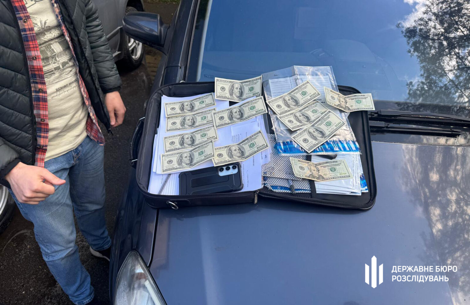 Гроші та документи у відкритій валізі на авто.