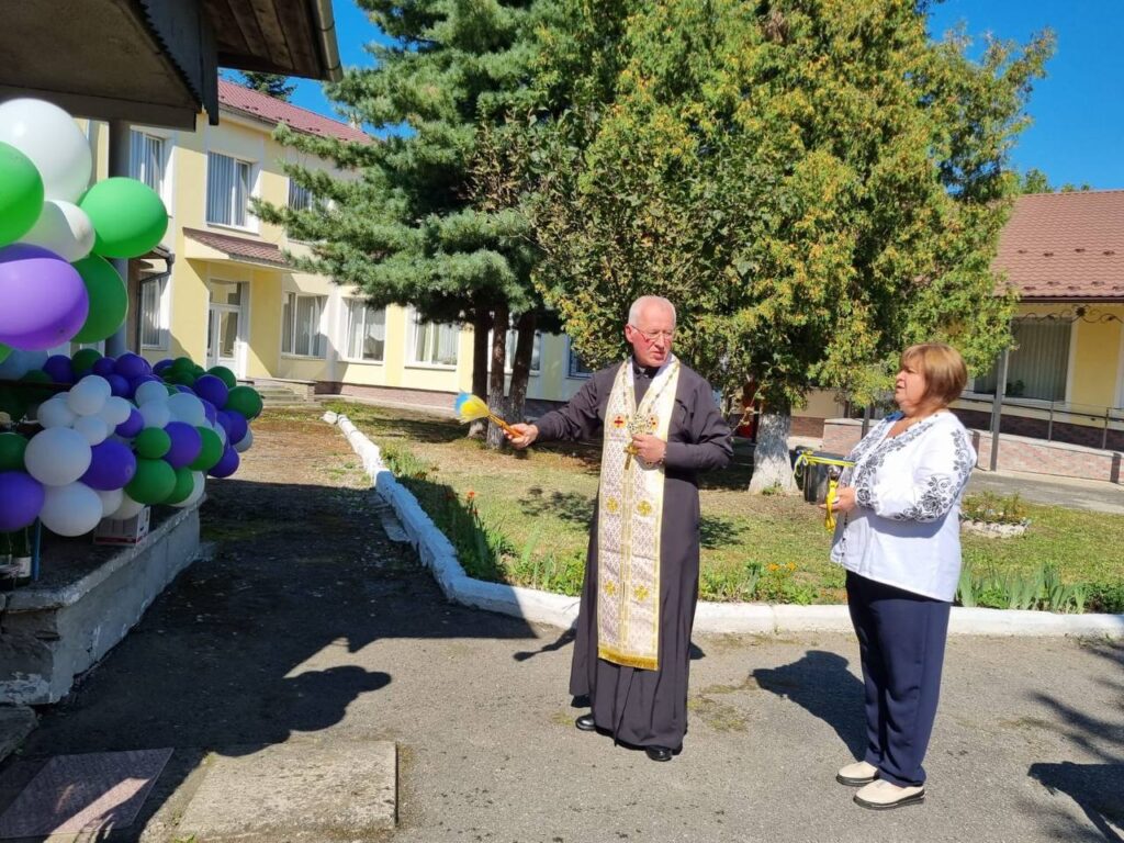 Священник освячує будівлю з повітряними кулями