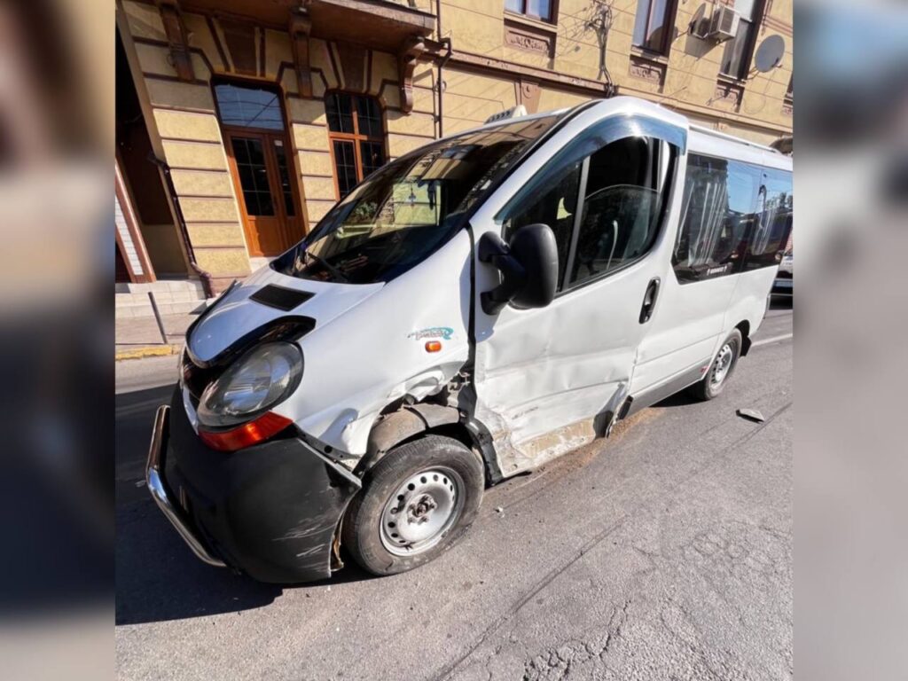 Білий мікроавтобус пошкоджений після аварії на вулиці.