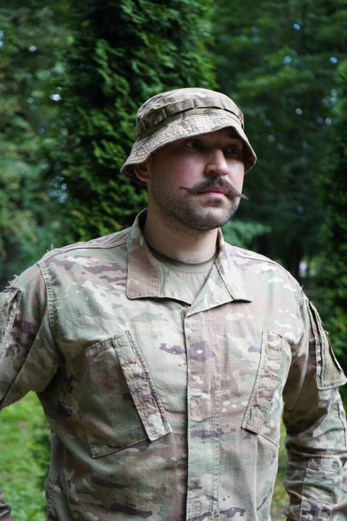 Чоловік у камуфляжі на природі