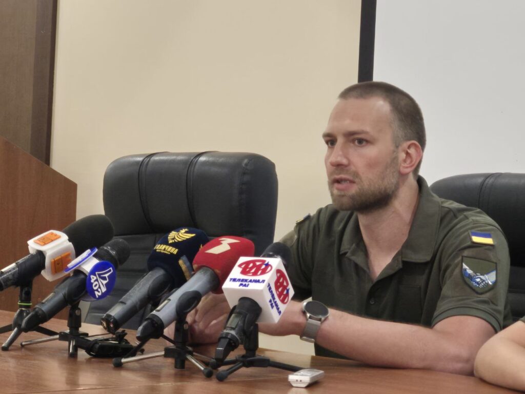 Чоловік на пресконференції перед мікрофонами
