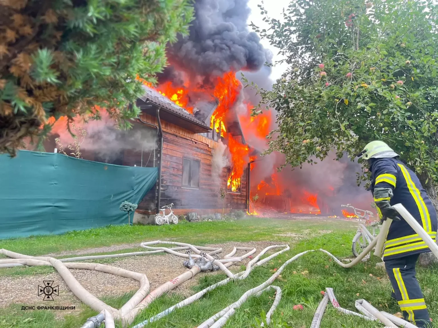 Пожежа у дерев'яному будинку, пожежник гасить вогонь