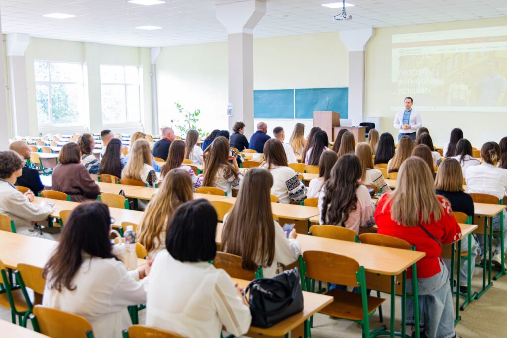 Лекція у великій аудиторії з багатьма студентами.