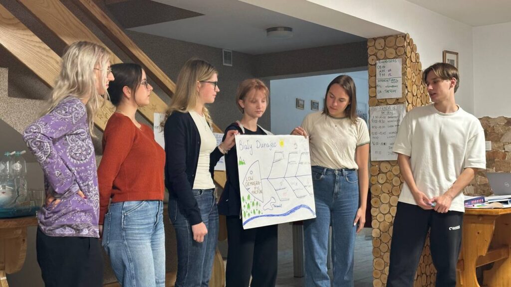 Група людей презентує плакат у приміщенні