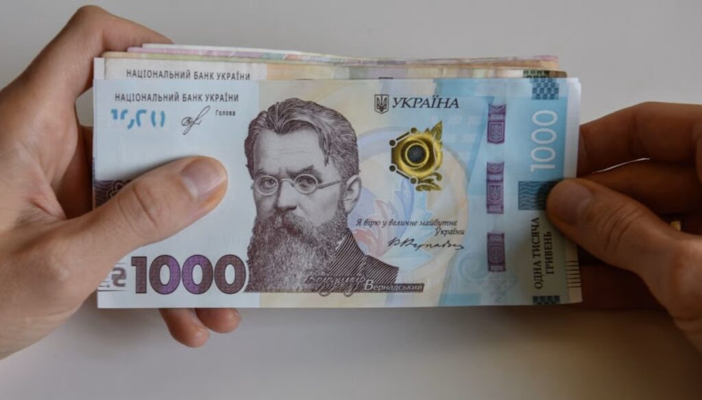 Купюри тисяча гривень у руках людини