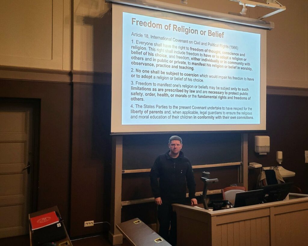 Чоловік перед екраном з текстом про релігійну свободу