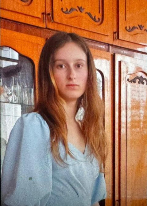 Дівчина в блакитній сукні біля шафи