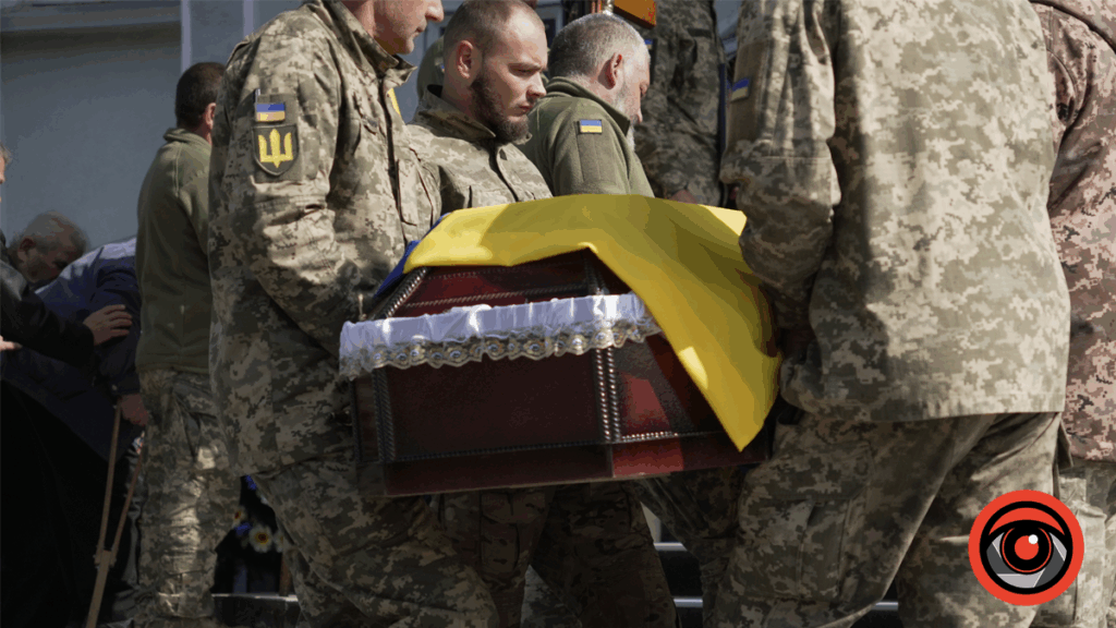 Військові несуть труну з українським прапором.