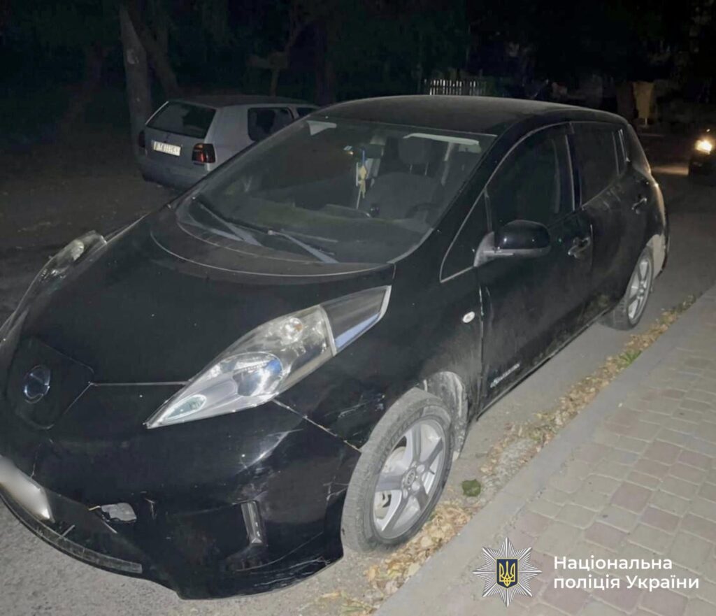Чорний автомобіль припаркований на вулиці вночі.