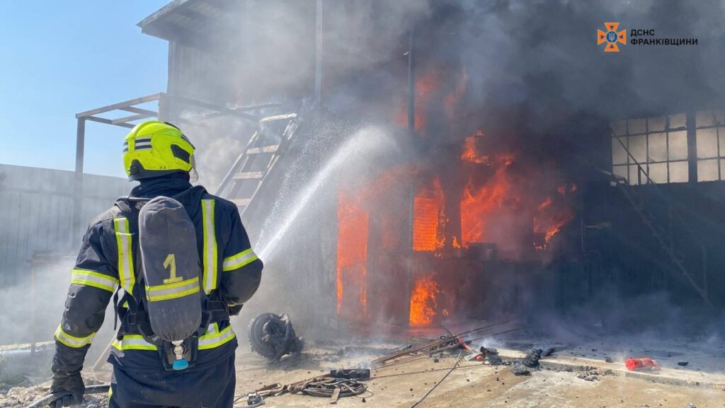 Пожежник гасить вогонь у палаючій будівлі