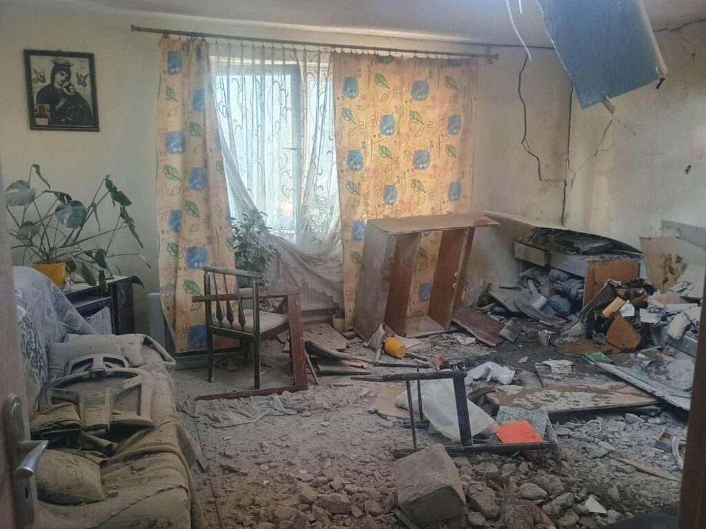 Зруйнована кімната з меблями та уламками, денне світло