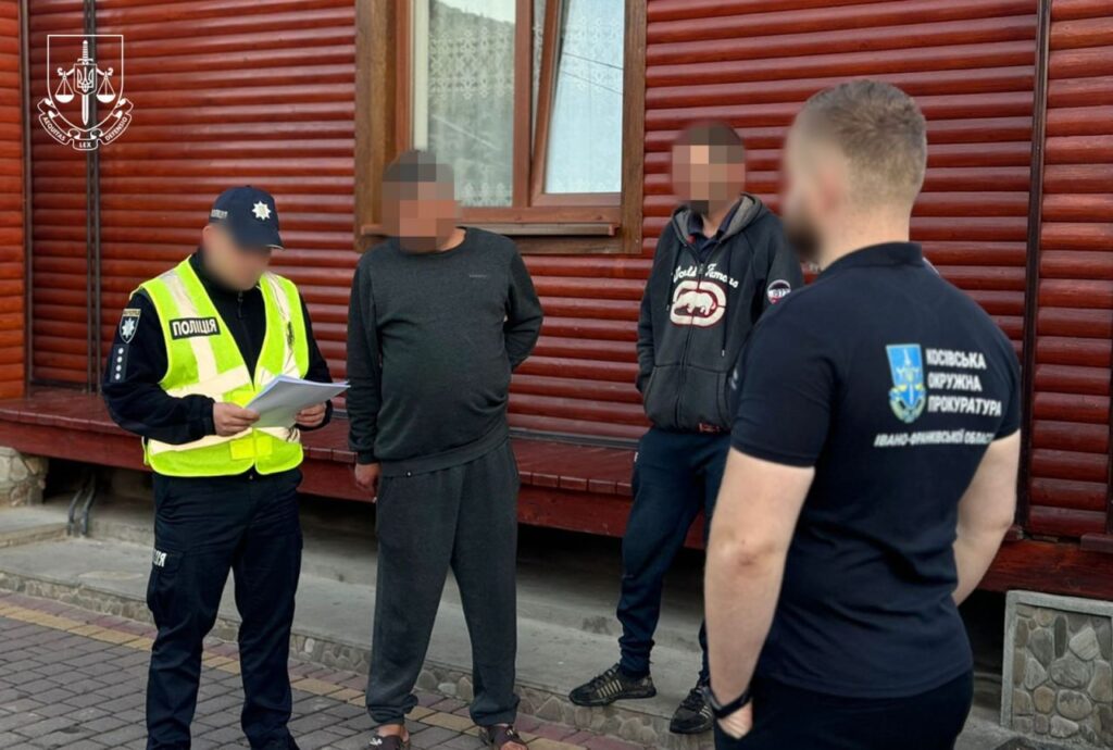 Правоохоронці проводять обговорення з чоловіками біля будівлі.